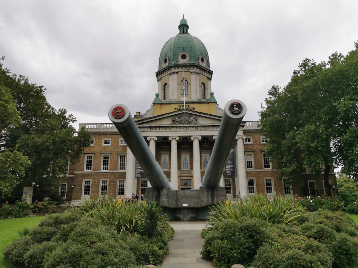 La facciata con cupola e colonnato dell'IWM London (Imperial War Museum) a Lambeth, con due grandi cannoni navali sul prato davanti
