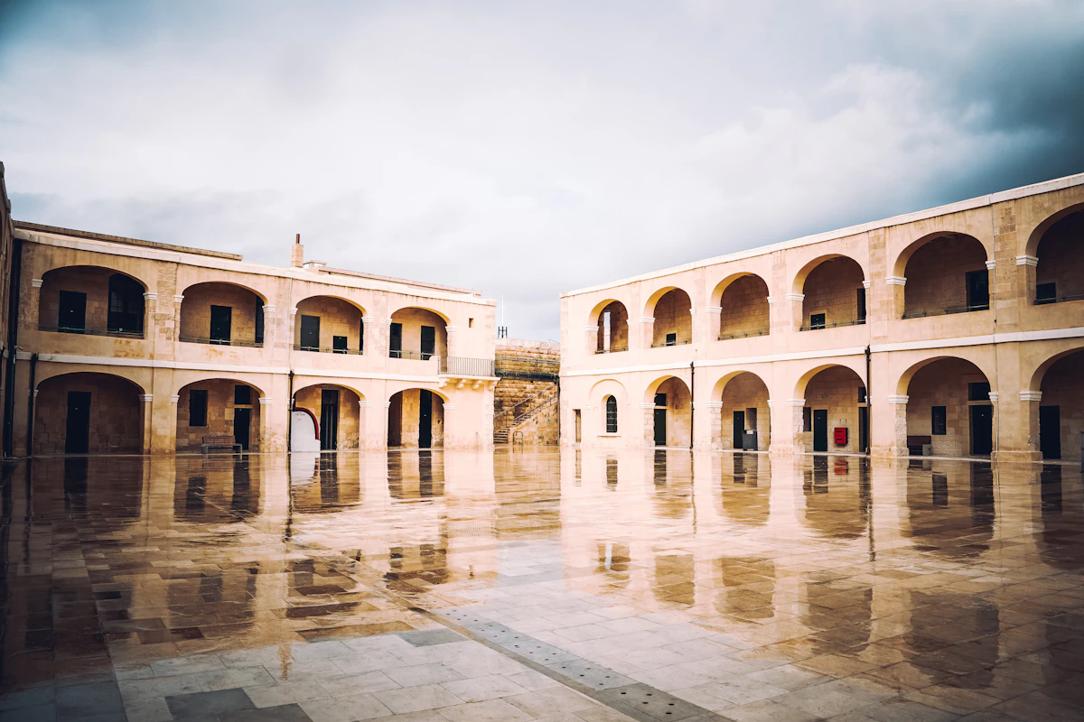 A large arcaded stone courtyard within a historic Valletta fortification