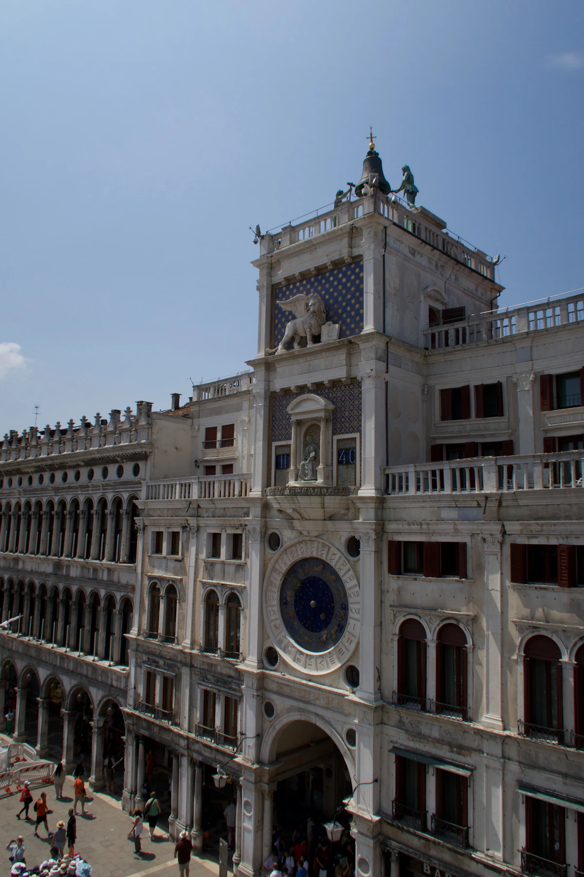 La Torre dell'Orologio (Torre dell'Orologio di San Marco), un'ornata torre dell'orologio rinascimentale che si affaccia su una trafficata piazza cittadina europea a Venezia